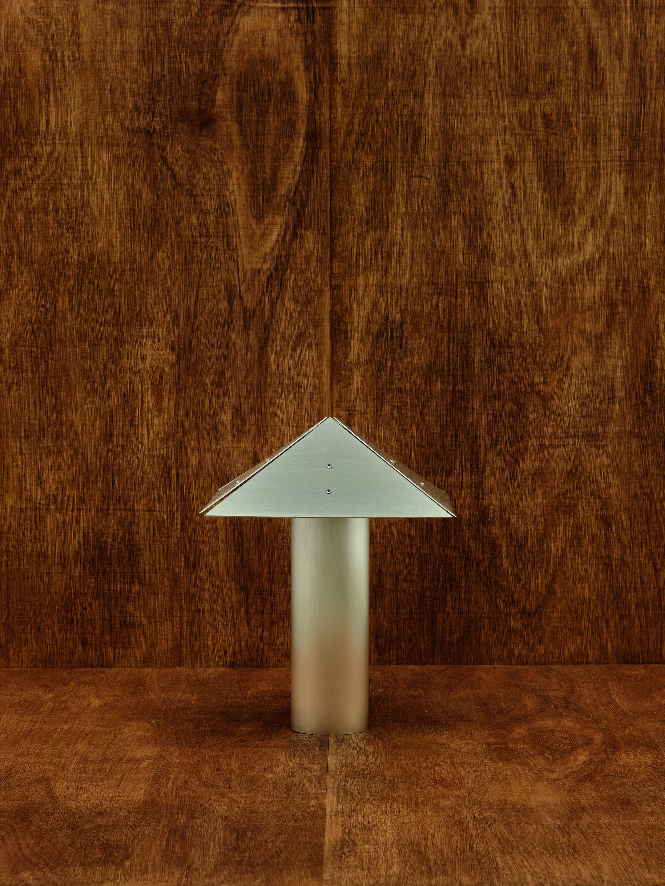 Metallic triangular object on a wooden surface